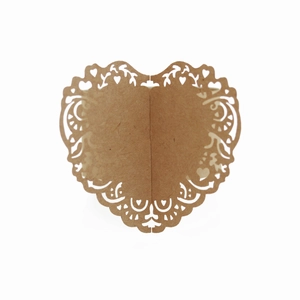 Detail of laser-cut heart-shaped brown kraft paper napkin ring with floral vine patterns