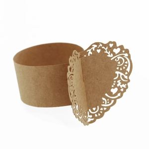 Detail of laser-cut heart pattern on brown kraft paper napkin ring for weddings