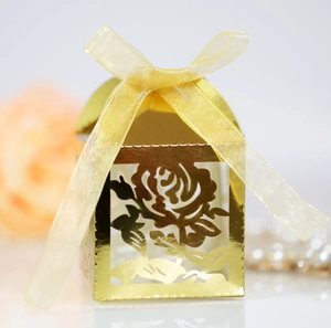 Macro shot of gold hollow rose wedding favor box with an elegant yellow silk ribbon bow
