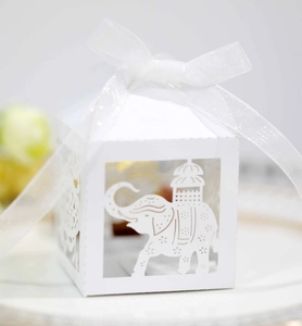 Close-up of white laser-cut elephant candy box with floral patterns and organza ribbon