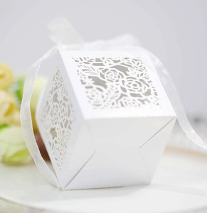 Detailed macro view of laser-cut white rose favor box with elegant organza ribbon