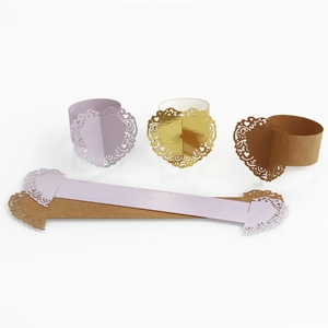Macro view of laser-cut heart paper napkin rings in lavender and gold for wedding decor