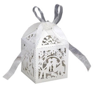 Laser-cut white wedding favor box featuring bride and groom silhouette and ribbon detail