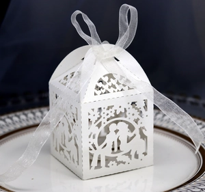 Laser-cut white wedding favor box with romantic couple silhouette and ribbon detail