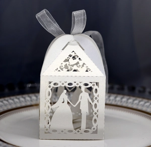 Laser-cut white wedding favor box with bride and groom silhouette and silver ribbon
