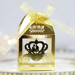Detail of laser-cut gold crown carriage wedding candy box with a silk ribbon bow
