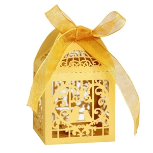 Laser-cut yellow birdcage favor box with intricate floral patterns and ribbon