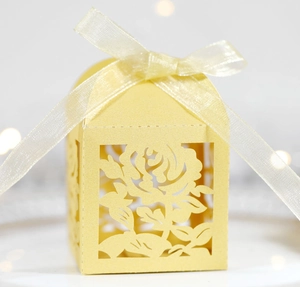 Detailed laser-cut yellow gift box with rose pattern and ivory ribbon bow on top