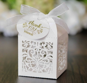 Detailed laser-cut hollow white gift box with ivory ribbon and thank you tag close-up