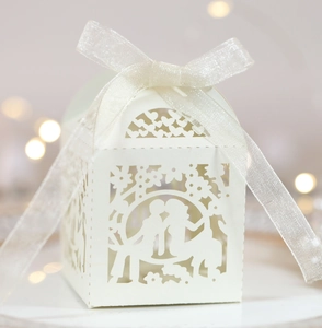 Detailed laser-cut candy box with romantic silhouette and elegant white ribbon bow