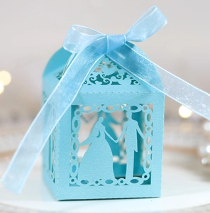 Detail showing laser-cut wedding silhouette on light blue gift box with satin ribbon bow