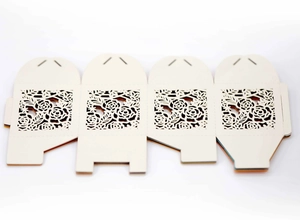 Flat lay of laser-cut paper gift box template with intricate rose floral pattern