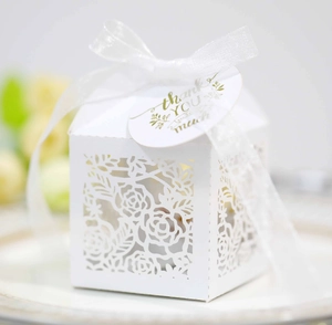Macro view of white laser-cut floral candy box with ribbon and Thank You gift tag