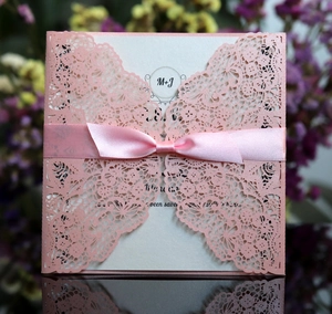 Detailed laser cut lace wedding invitation with pink silk ribbon and M+J initials monogram
