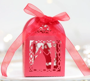 Red laser-cut wedding candy box with bride and groom silhouette and ribbon bow