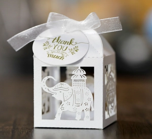 Detailed laser-cut white wedding favor box with elephant pattern and thank you tag