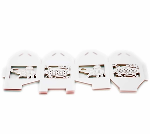 Flat lay of laser-cut wedding favors with elephant and floral patterns in white paper