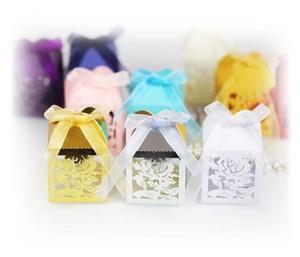 Detail of laser-cut rose hollow candy boxes with elegant satin ribbons and pearlescent finish