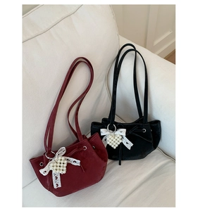 Detailed shot of velvet handbags with white lace bows and heart-shaped pearl charms