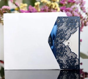 Navy blue laser-cut wedding invitation set with silk ribbon and elegant floral hollow pattern