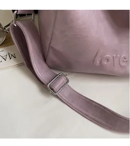 Detail of lilac purple leather tote with embossed love lettering and wide shoulder strap