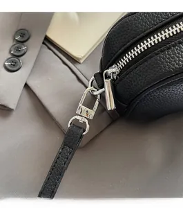 Close-up of black lychee grain leather with premium silver metal zipper and clasp