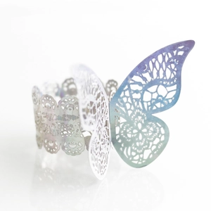 Detail view of laser-cut butterfly napkin ring with blue-purple gradient and pearly finish