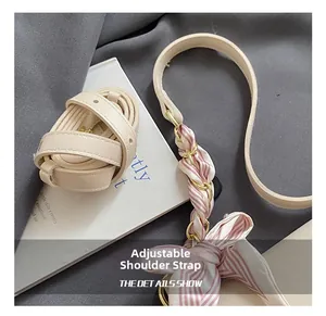 Detail of adjustable beige strap with woven pink silk scarf and gold chain accents
