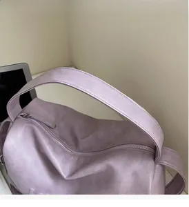Macro shot of ergonomic wide handle and smooth metal zipper on lavender tote bag