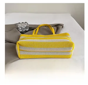 Detalle de la base tejida resistente en un bolso tote de punto a rayas amarillas y blancas