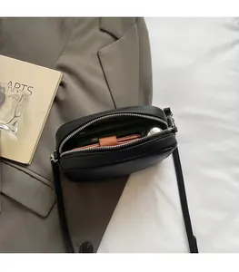 Detail of black pebbled leather crossbody bag showing large internal storage space