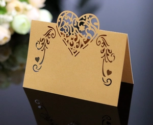 Macro view of laser-cut heart seat card with floral patterns on reflective surface