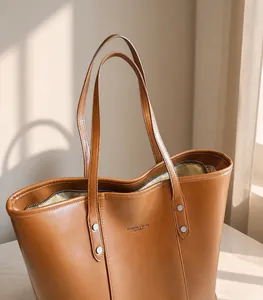 Detail view of brown PU leather tote bag with shoulder strap and embossed lettering