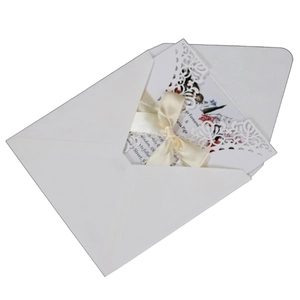 Invitación boda corte láser con diseño floral, lazo crema y sobre blanco puro