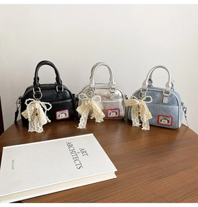 Détail de mini sacs Boston avec écussons de chien et breloques de nœuds en dentelle décoratifs