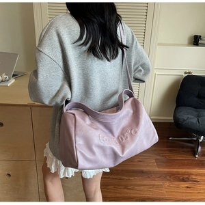 Detail showing the embossed LOVE 105C text on a soft purple leather crossbody bag