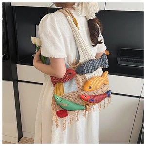 Detail of bohemian knit tote bag featuring colorful 3D fish charms and tassel fringe