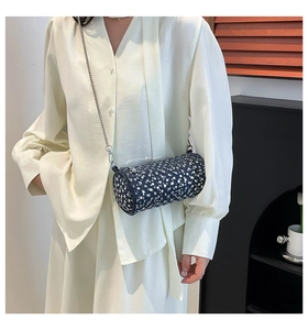 Détail du sac polochon en strass avec chaîne en perles porté sur une robe en soie