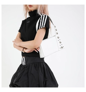 Detailed view of silver metallic rivets and white PU leather texture on the shoulder strap
