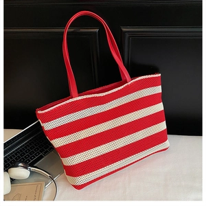 Detalle del bolso tote de punto con rayas rojas y blancas y asas de cuero duraderas
