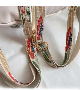 Dettaglio della tracolla jacquard colorata con fibbia dorata e cerniera metallica