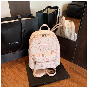 Detail of pink mini backpack featuring cartoon bear prints and stylish front pocket