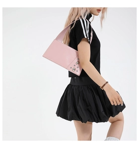 Pink punk-style shoulder bag with silver rivet details shown on a female model