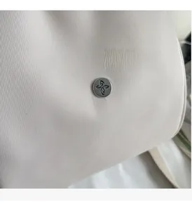 Dettaglio del tessuto a righe beige e della fibbia in metallo grigio sullo zaino