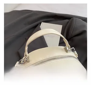 Dettaglio della borsa trapuntata crema con strass e finiture in metallo argentato