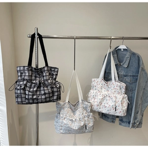 Detail of floral tote bags with side drawstring pockets and durable canvas texture