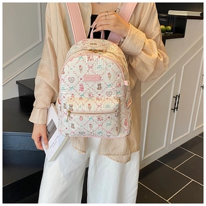Close-up of cute cartoon bear embossed patterns and pink brand logo on white backpack