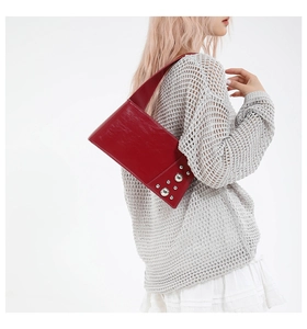 Detailed view of punk style burgundy leather handbag with metallic silver stud accents