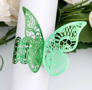 Detail of laser-cut green butterfly napkin ring with intricate hollow lace patterns