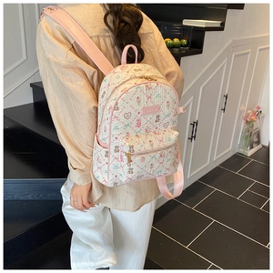 Detail of cute printed backpack with pink straps shown worn by a model on stairs